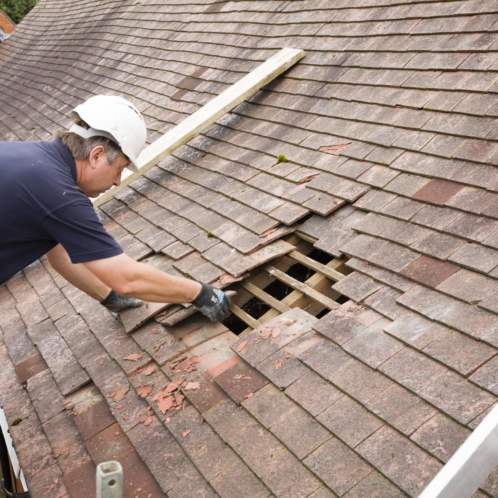 Roofer repairing damaged shingles on a home in Cypress, TX